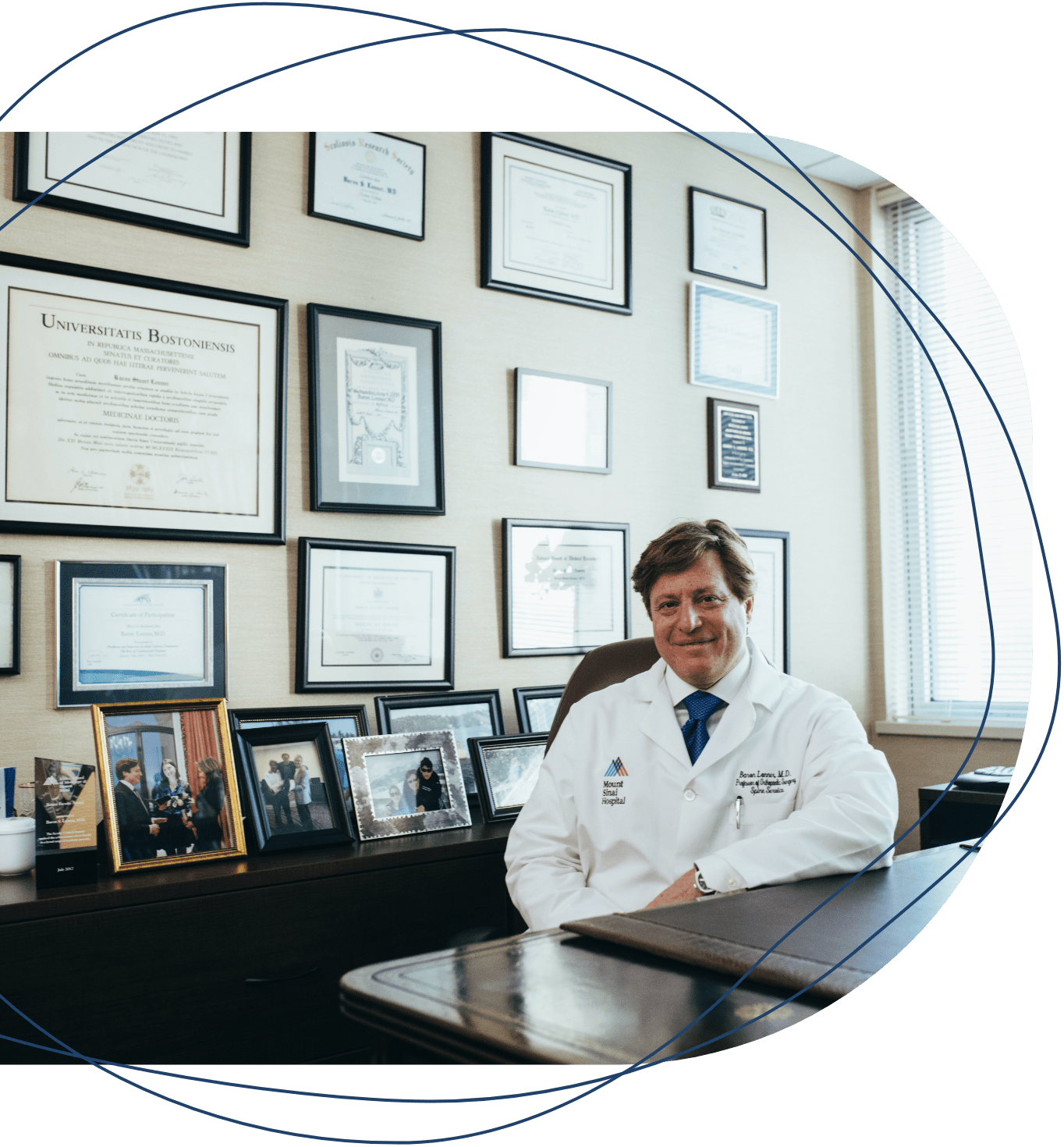 Doctor sentado en su consultorio mostrando sus logros académicos
